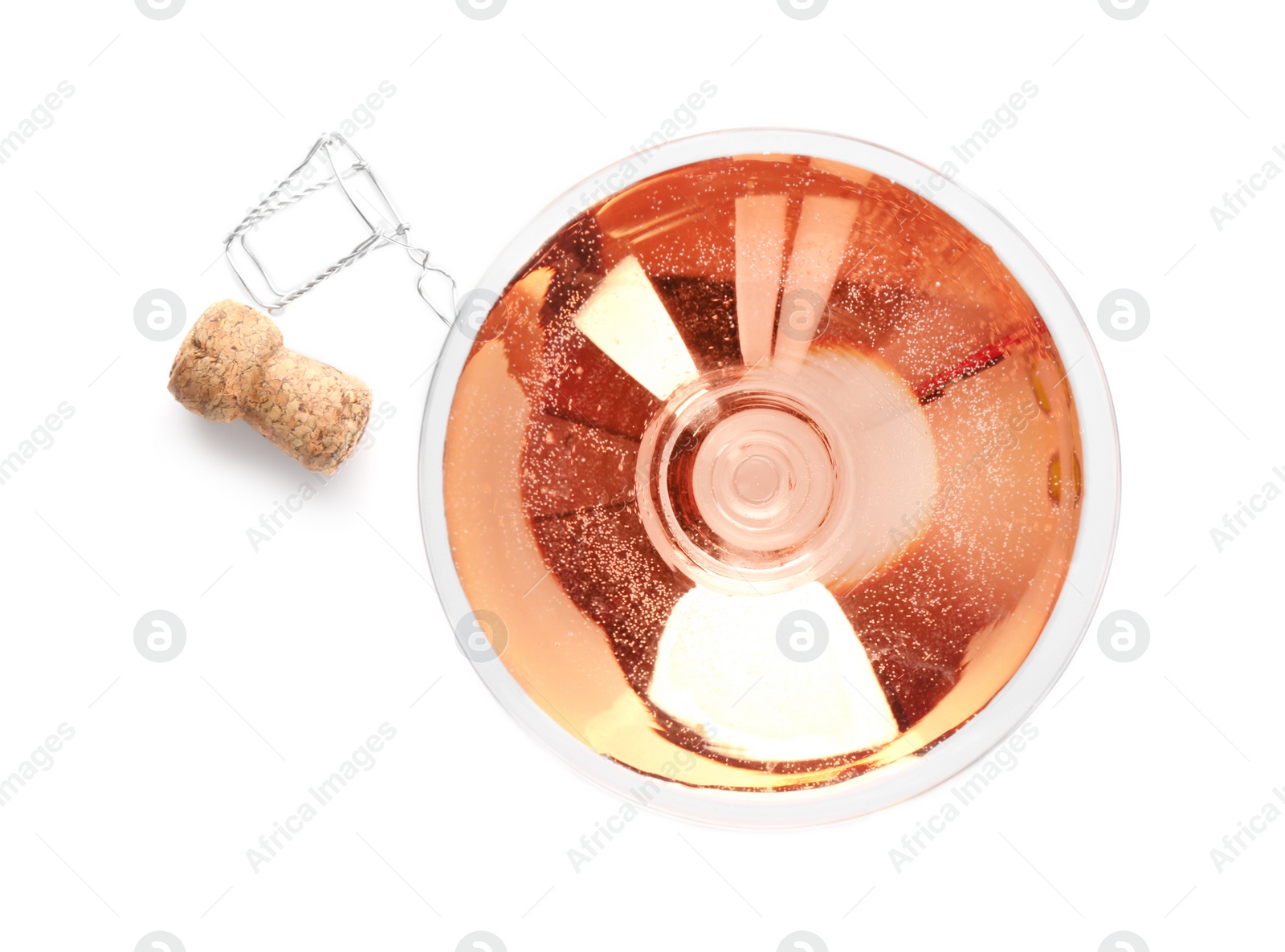 Photo of Glass of rose champagne and cork plug on white background, top view