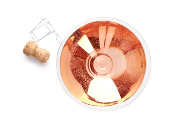 Photo of Glass of rose champagne and cork plug on white background, top view