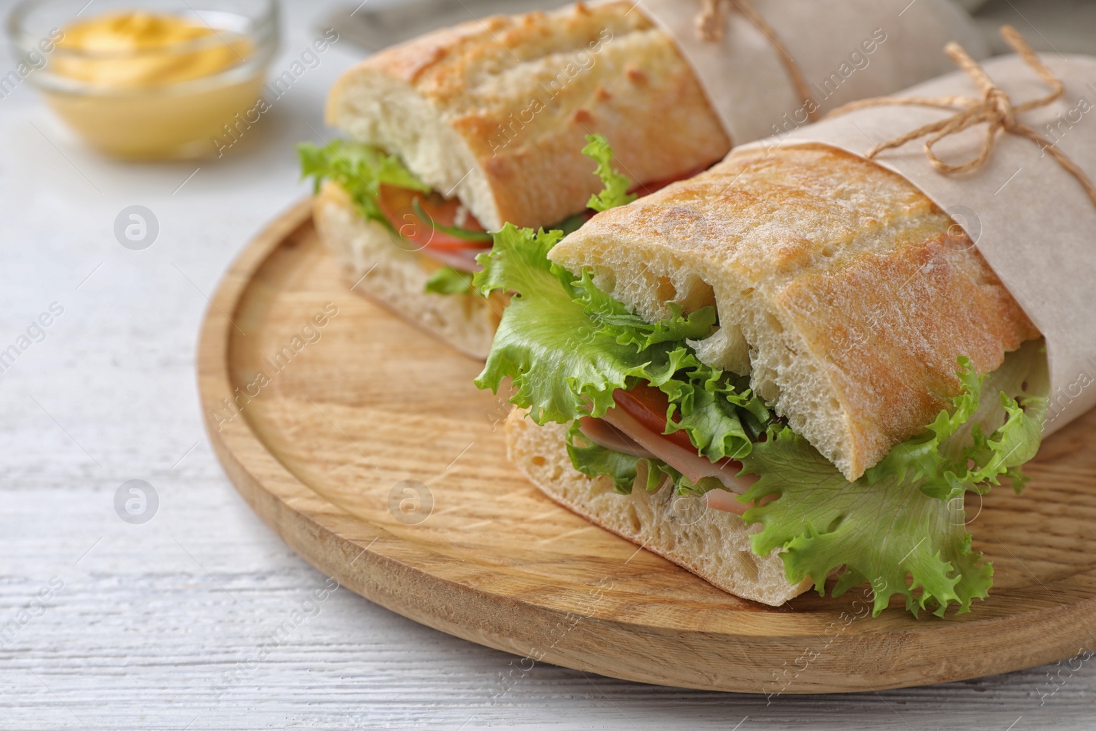 Photo of Tasty sandwiches with ham on white wooden table, closeup