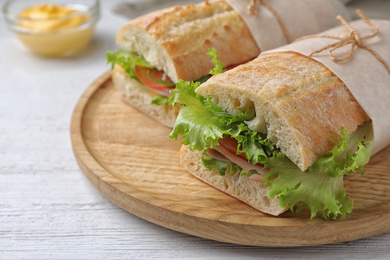 Photo of Tasty sandwiches with ham on white wooden table, closeup