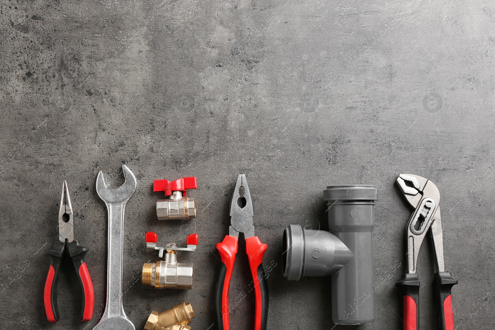 Photo of Flat lay composition with plumber's tools and space for text on gray background