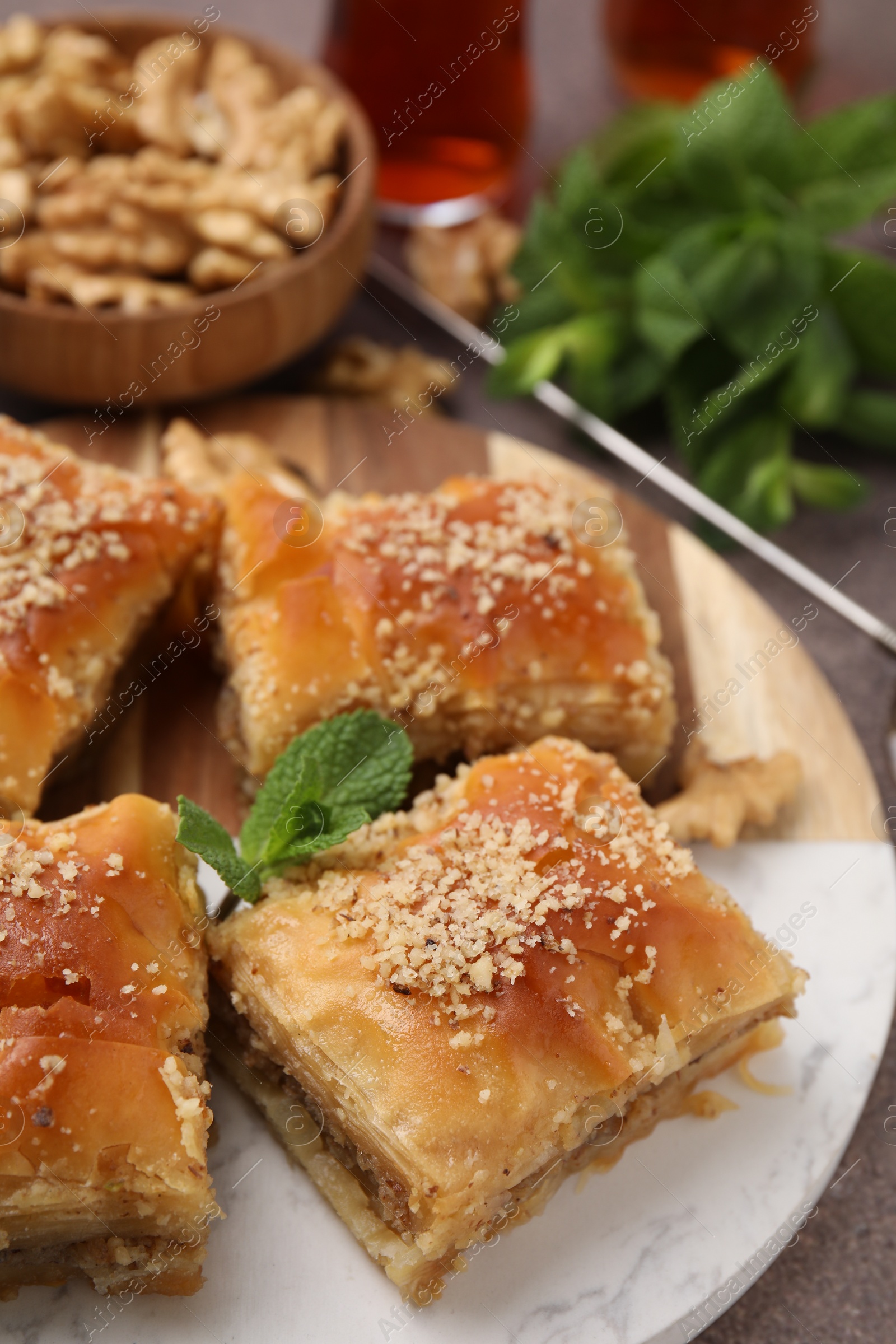 Photo of Eastern sweets. Pieces of tasty baklava on brown table, closeup