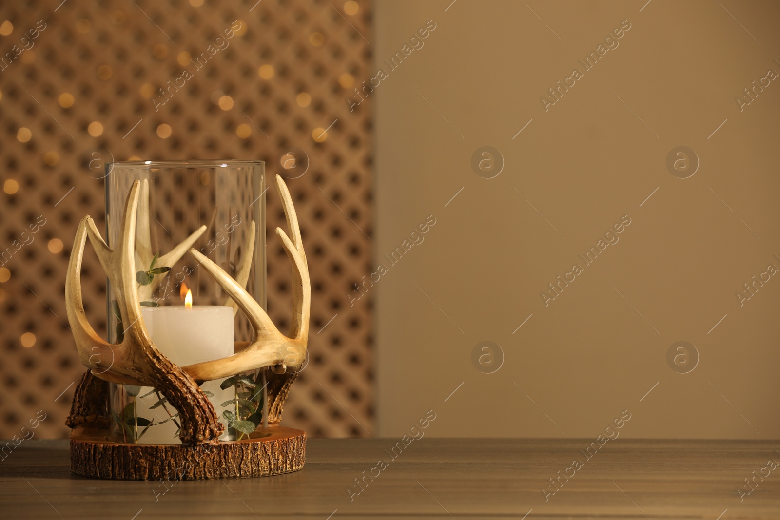 Photo of Burning candles in beautiful holder on wooden table, space for text