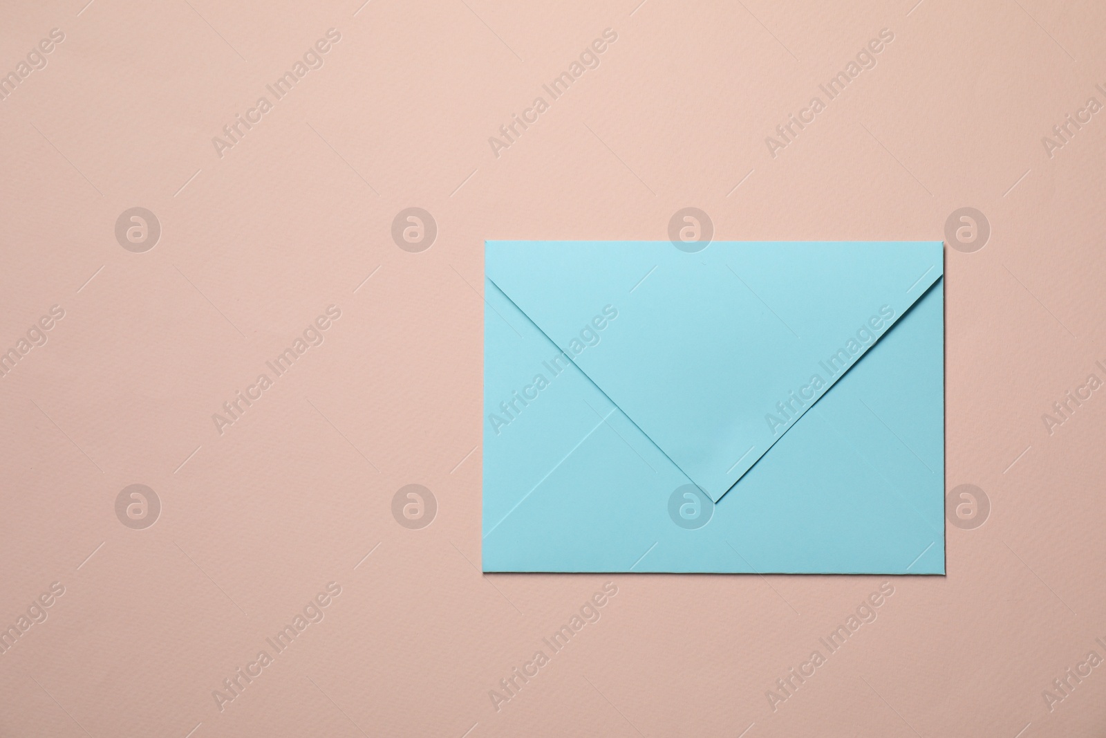 Photo of Letter envelope on beige background, top view. Space for text
