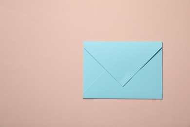 Letter envelope on beige background, top view. Space for text