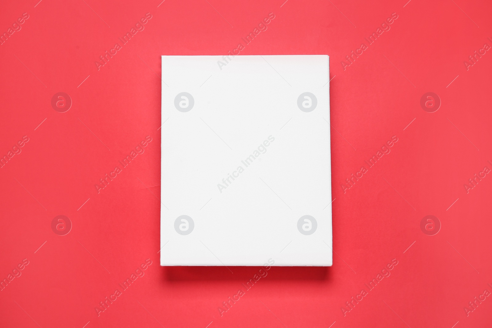 Photo of Blank canvas on red background, top view. Space for design