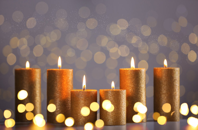 Burning candles on grey background, bokeh effect