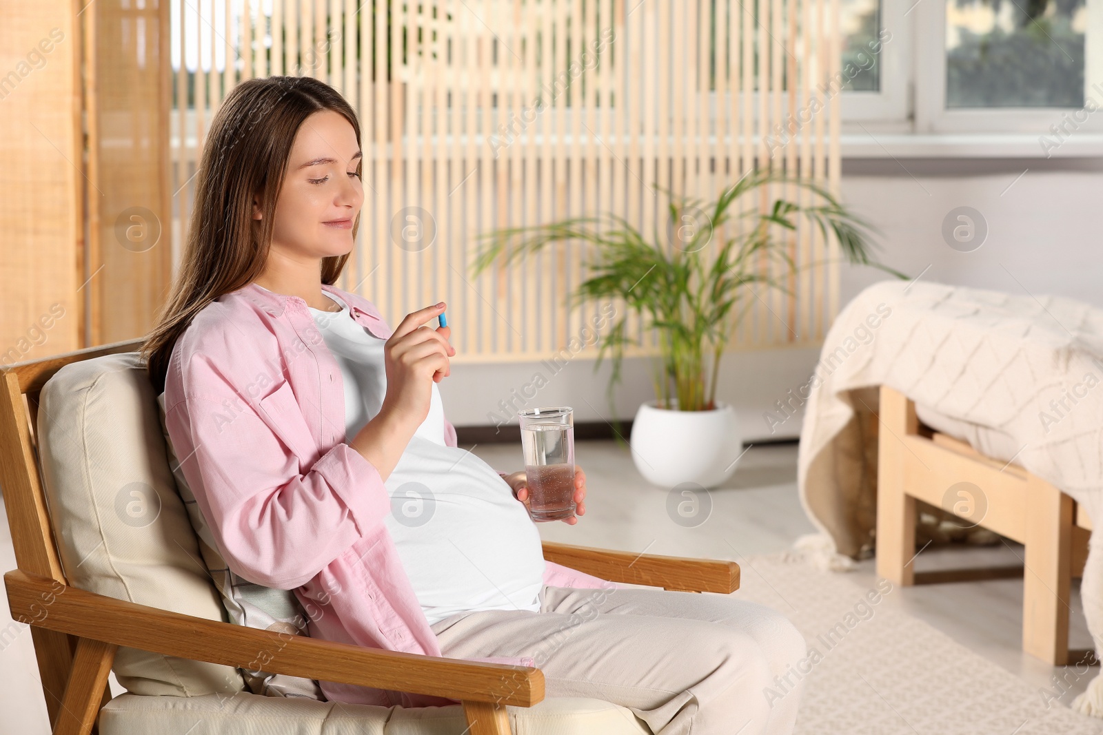 Photo of Beautiful pregnant woman taking pill at home