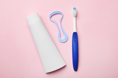 Photo of Tongue cleaner, tooth paste and brush on color background, flat lay