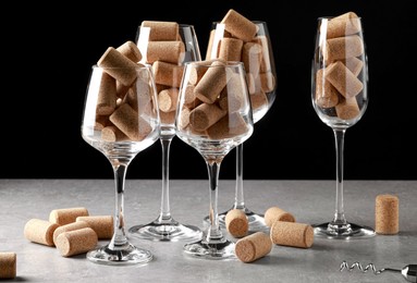 Photo of Glasses with wine corks and corkscrew on light table