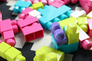 Photo of Colorful plastic building blocks on carpet, closeup