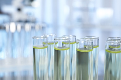 Test tubes with liquid on blurred background, closeup. Laboratory analysis