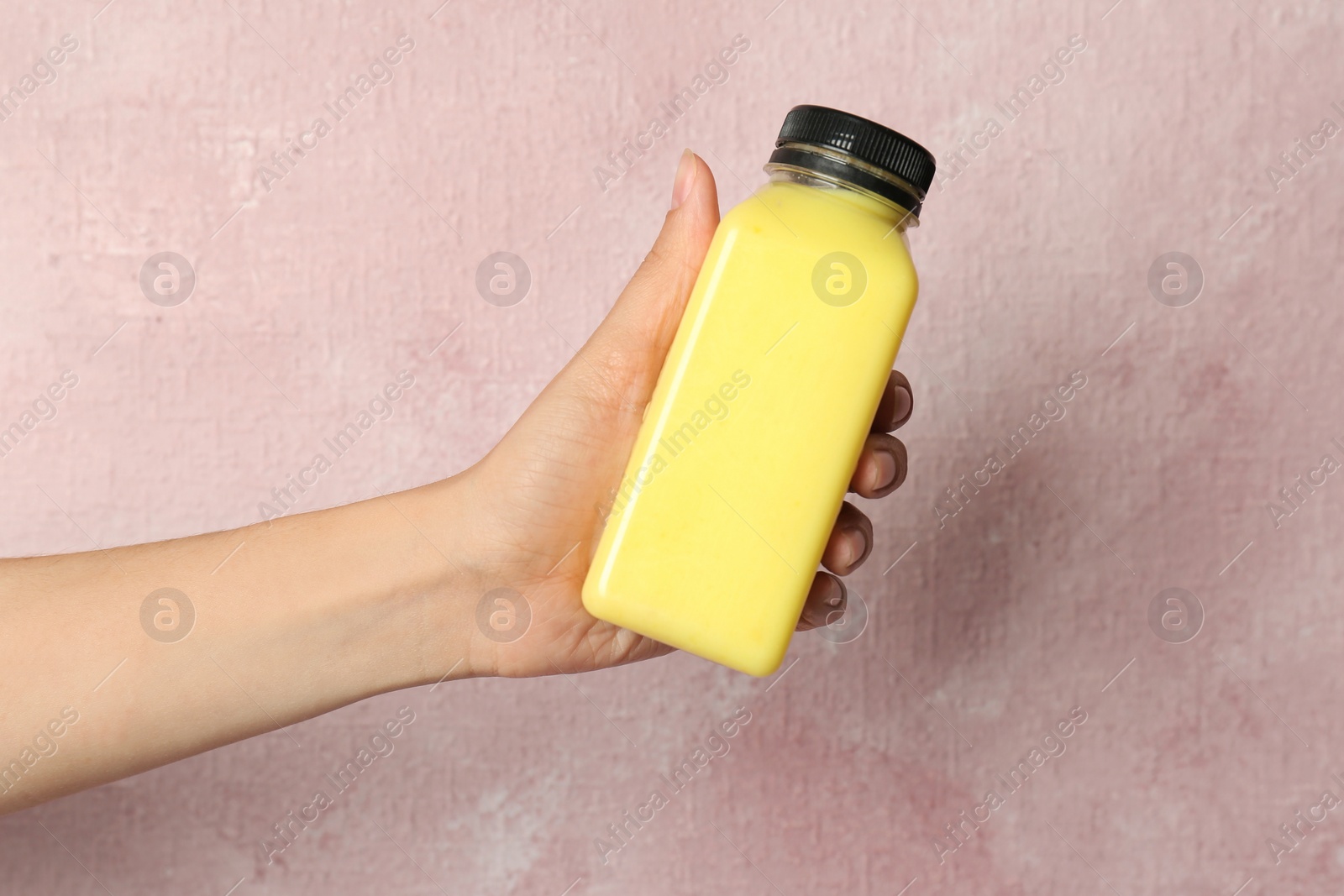 Photo of Woman holding bottle with delicious smoothie on color background