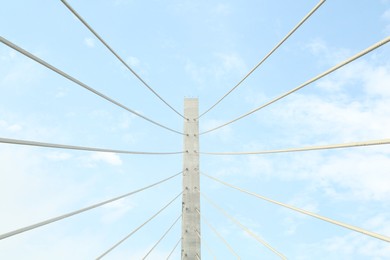 Photo of Beautiful modern bridge against blue cloudy sky, low angle view