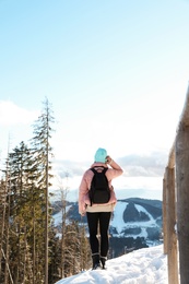 Photo of Woman with backpack enjoying mountain view during winter vacation. Space for text