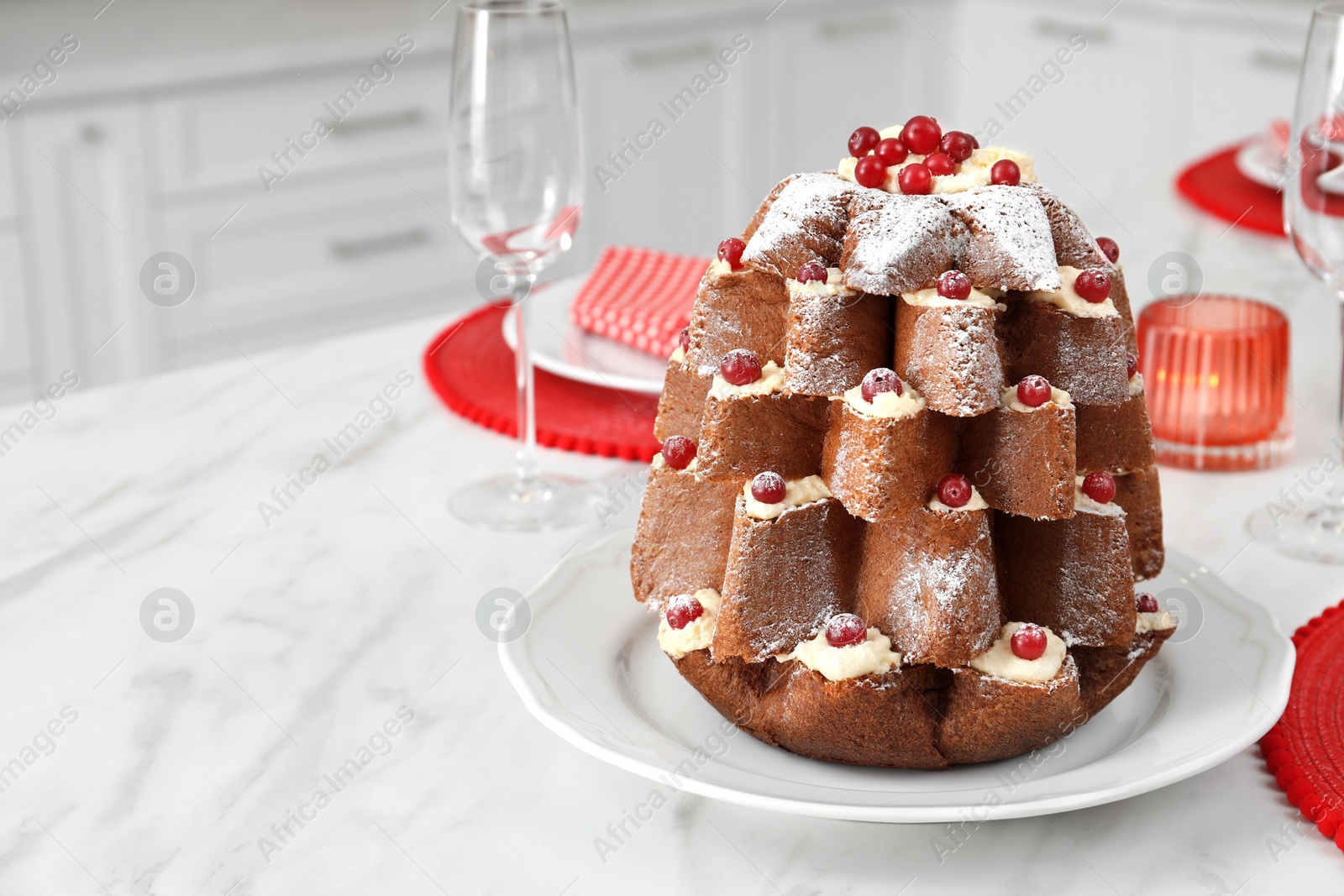 Photo of Delicious Pandoro Christmas tree cake decorated with powdered sugar and berries on white marble table. Space for text