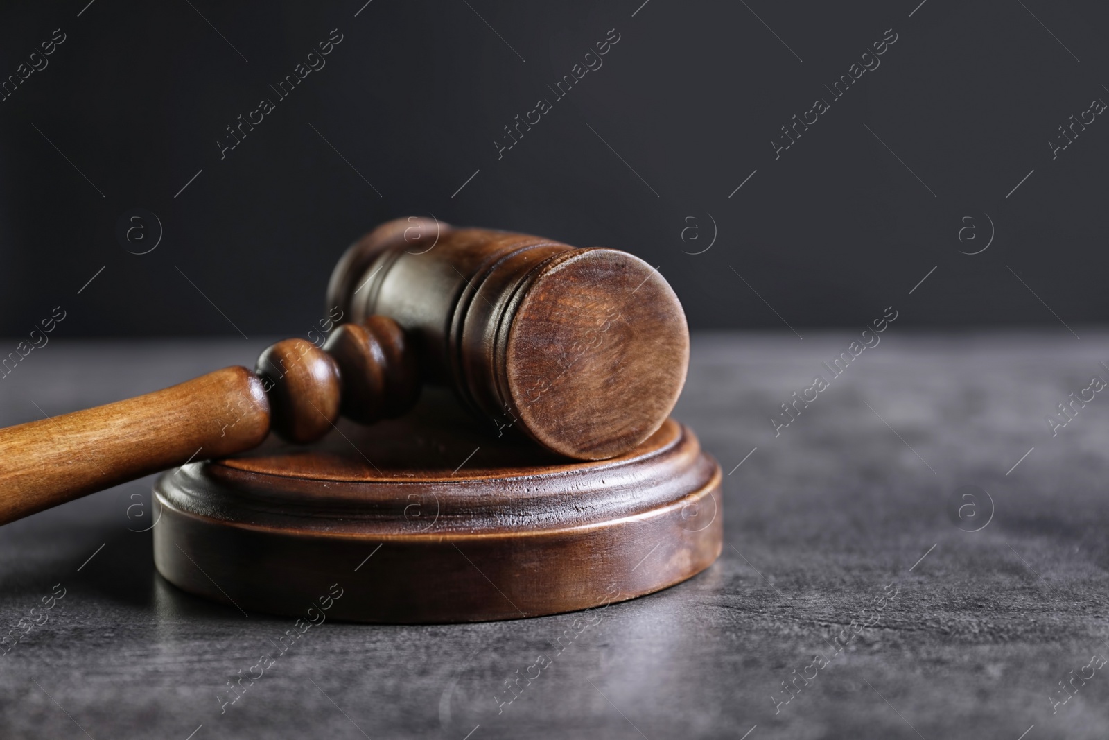 Photo of Judge's gavel on grey table. Law concept