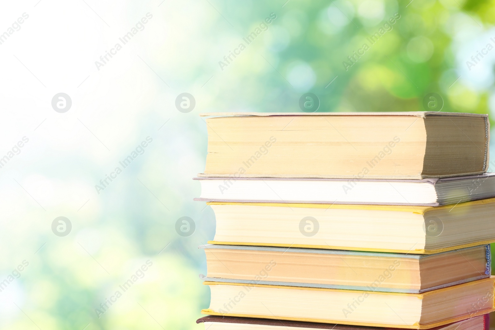 Image of Stack of books on blurred background, space for text. Bokeh effect 