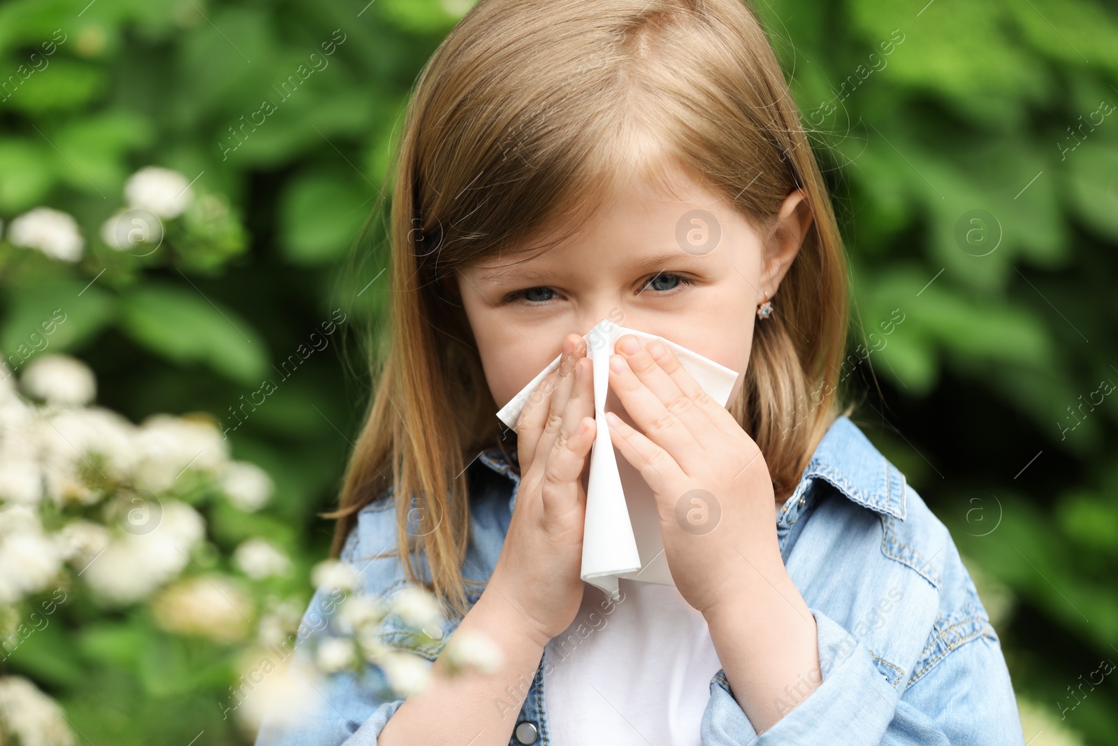 Photo of Little girl suffering from seasonal spring allergy outdoors