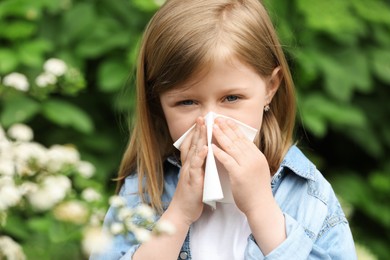 Photo of Little girl suffering from seasonal spring allergy outdoors