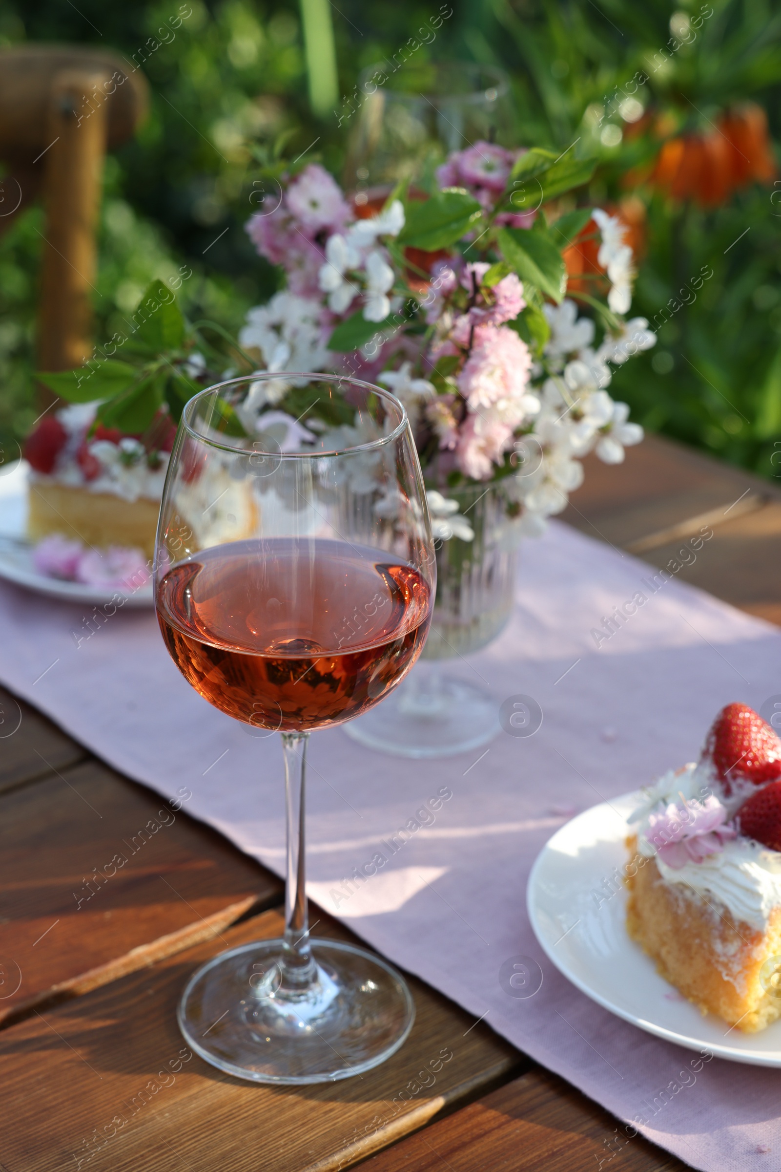 Photo of Glass of wine on table served for romantic date in garden