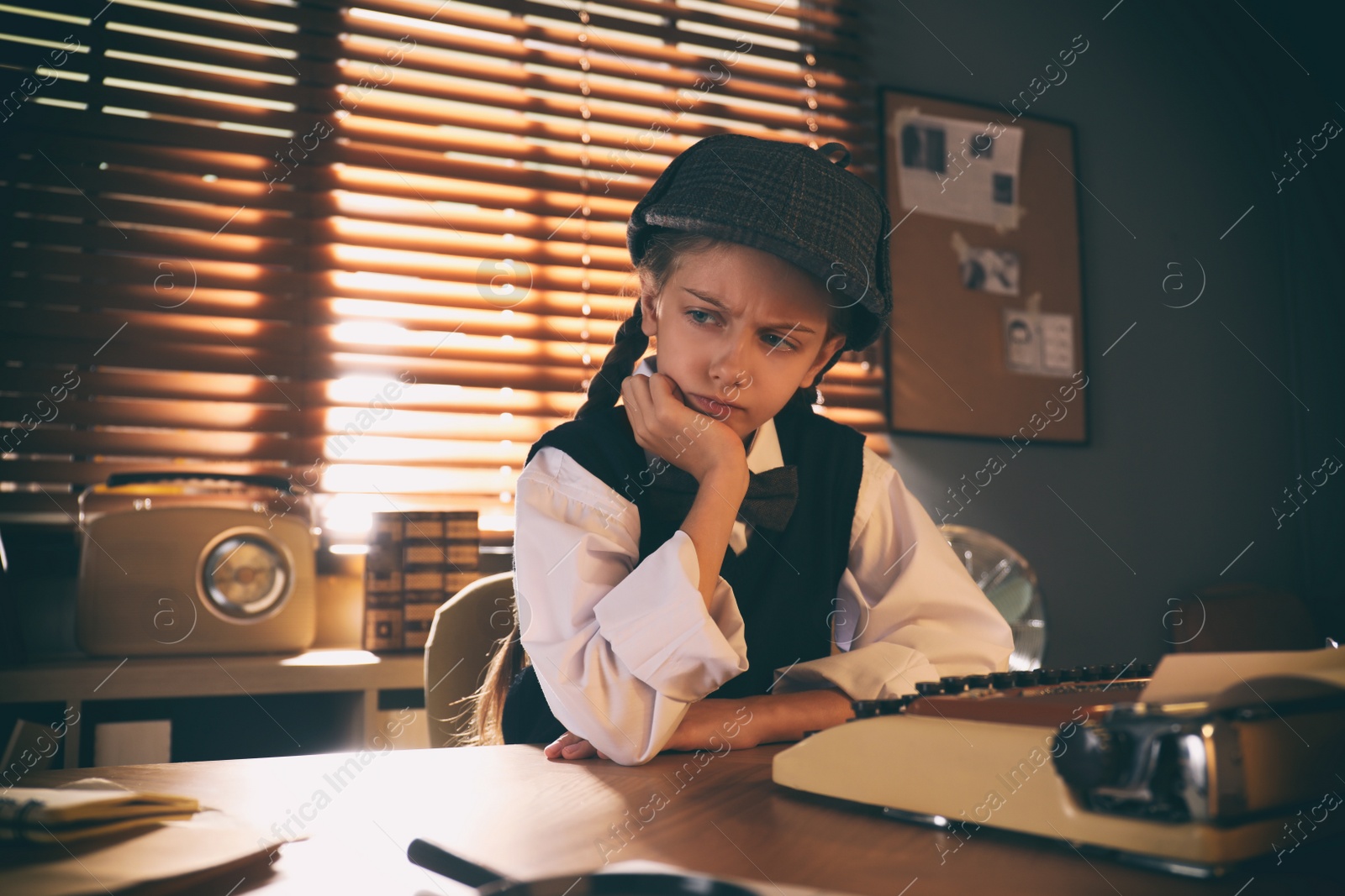 Photo of Cute little detective at table in office