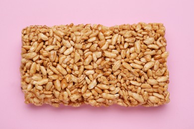 Photo of Puffed rice bar (kozinaki) on pink background, top view