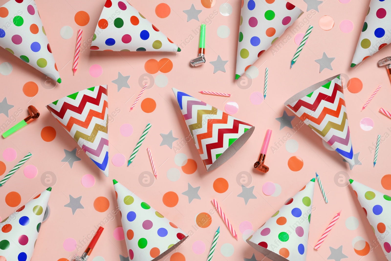 Photo of Flat lay composition with party cones and confetti on pink background