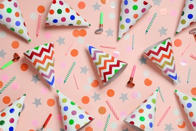 Photo of Flat lay composition with party cones and confetti on pink background