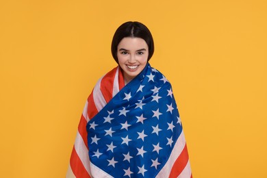 Photo of 4th of July - Independence Day of USA. Happy girl with American flag on yellow background