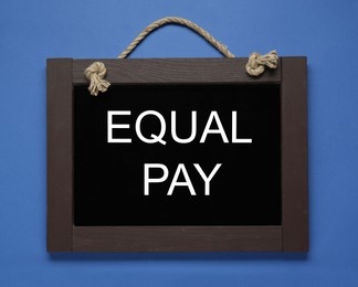 Photo of Blackboard with words Equal Pay on blue background, top view