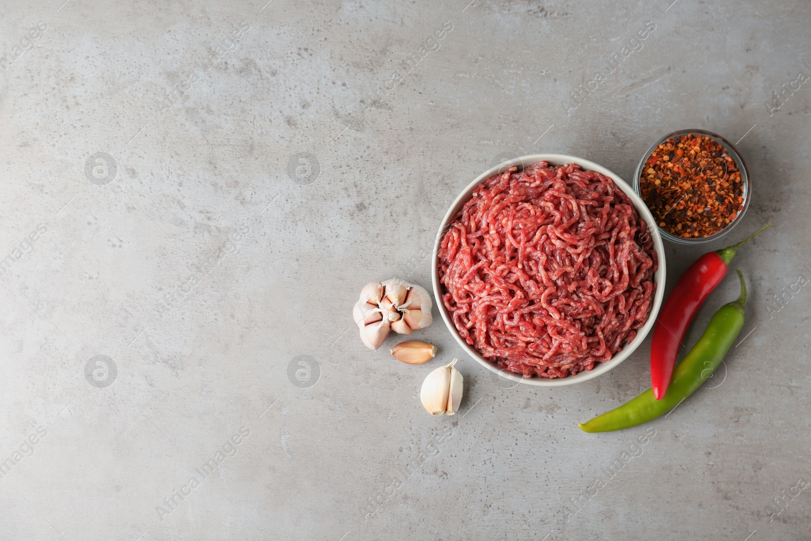 Photo of Flat lay composition with fresh raw minced meat on light table. Space for text