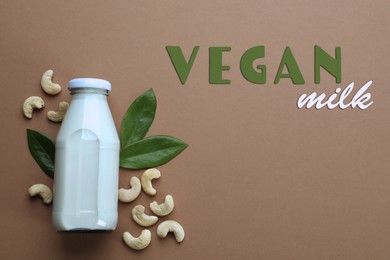 Delicious vegan cashew milk and nuts on brown background, flat lay