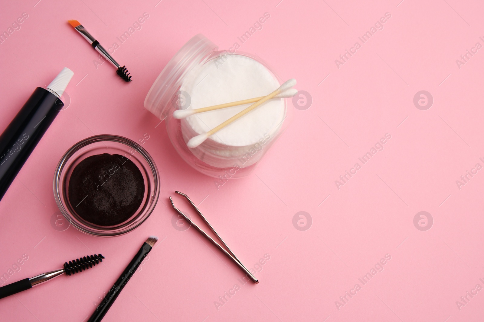 Photo of Flat lay composition with eyebrow henna and tools on pink background. Space for text