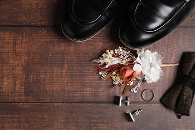 Wedding stuff. Flat lay composition with stylish boutonniere on wooden background, space for text