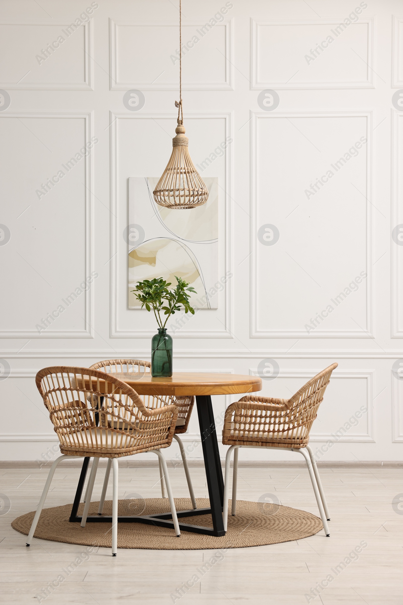 Photo of Dining room interior with comfortable furniture and green branches