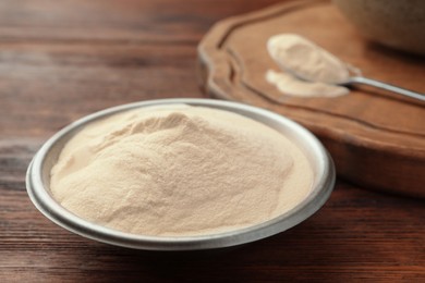 Photo of Bowl of agar-agar powder on wooden table, closeup