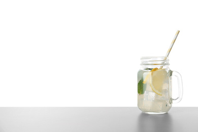 Photo of Delicious lemonade in mason jar on grey table against white background. Space for text