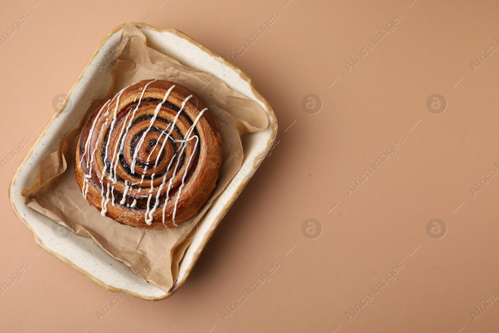 Photo of Sweet bun. Delicious roll with topping and poppy seeds on beige table, top view. Space for text