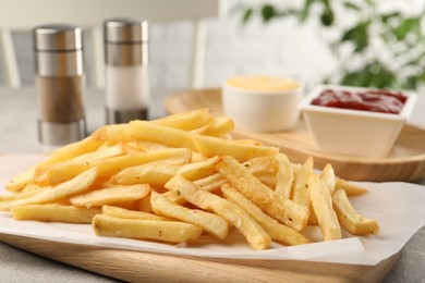 Delicious french fries on light grey table, closeup