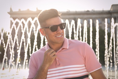 Photo of Handsome man wearing stylish sunglasses on city street