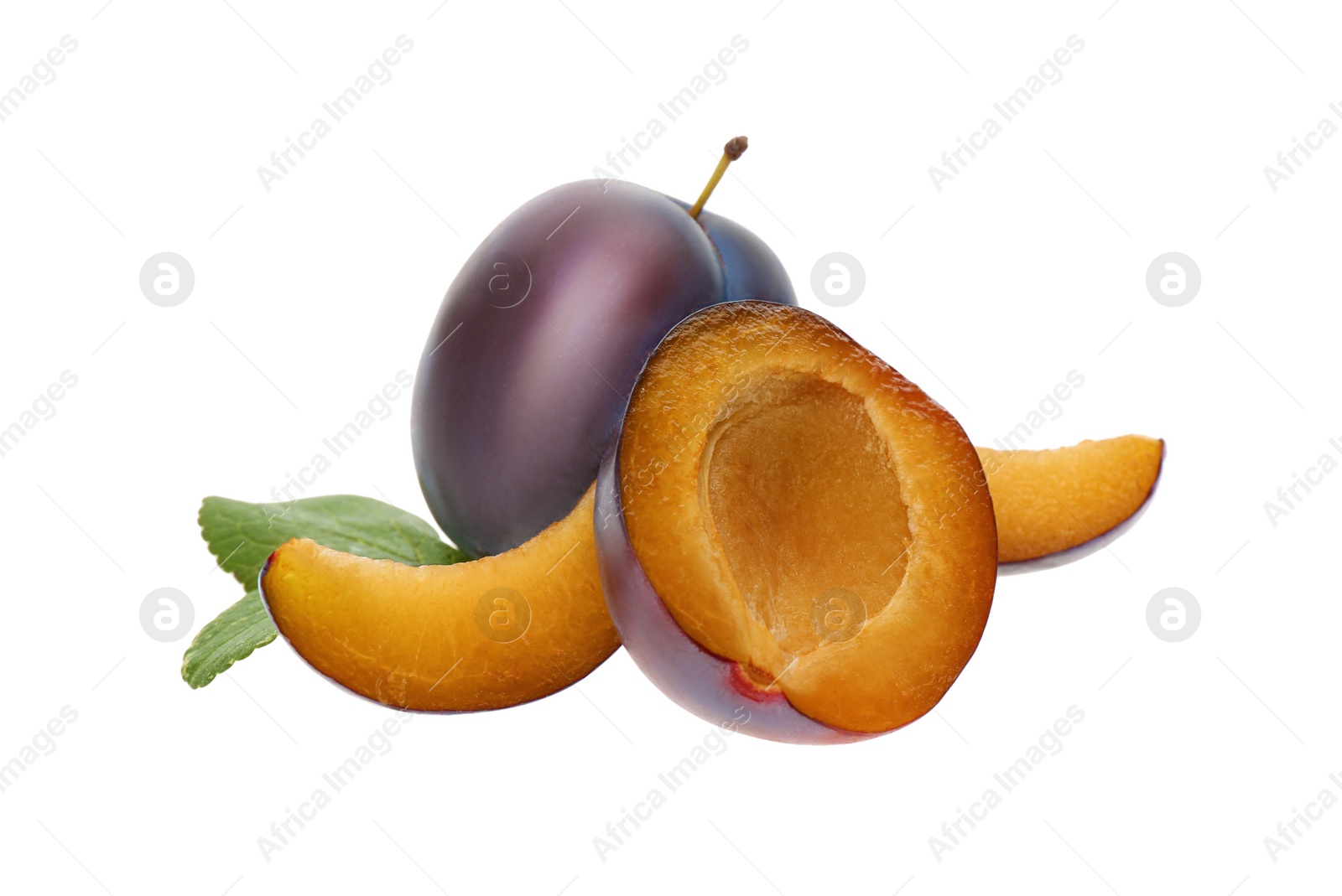 Photo of Whole and cut ripe plums with green leaves isolated on white