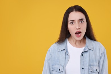 Photo of Portrait of surprised woman on yellow background. Space for text
