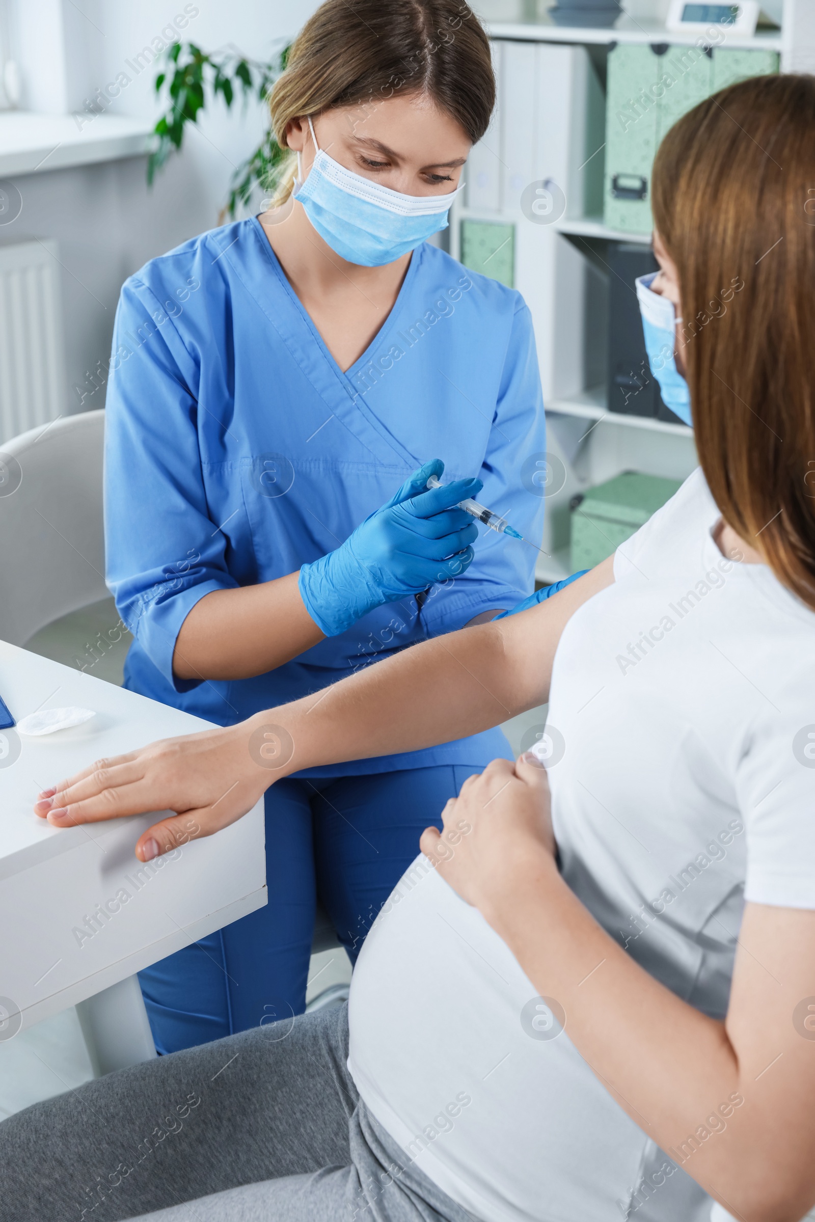 Photo of Doctor giving injection to pregnant woman in hospital