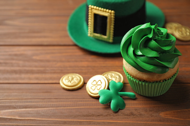 Composition with delicious decorated cupcake on wooden table. St. Patrick's Day celebration
