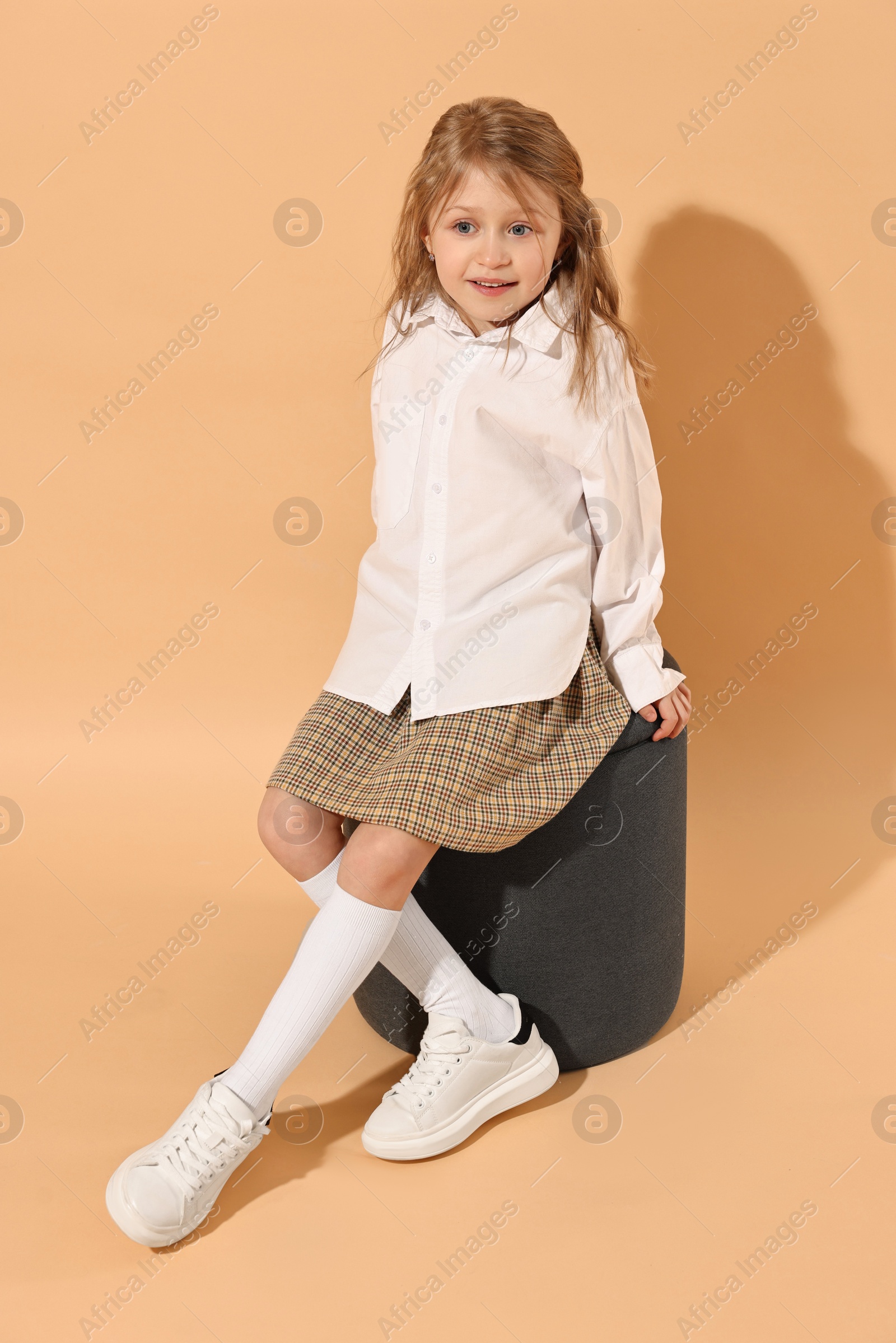 Photo of Fashion concept. Stylish girl on pale orange background