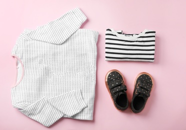 Photo of Flat lay composition with cute child clothes and shoes on color background