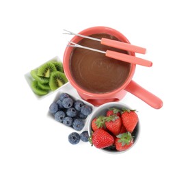 Photo of Fondue pot with melted chocolate, fresh berries, kiwi and forks isolated on white, top view