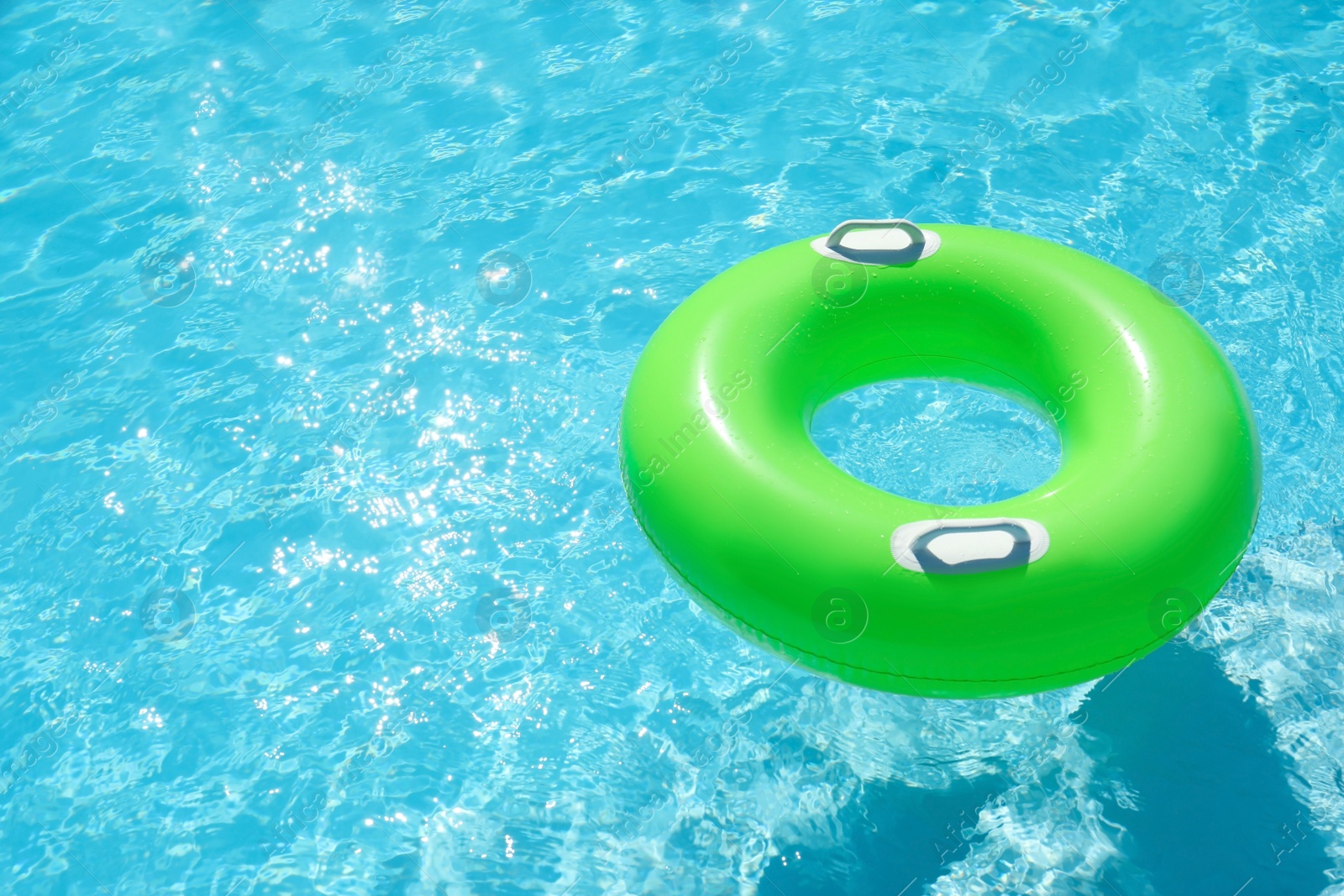 Photo of Inflatable ring floating in swimming pool on sunny day. Space for text