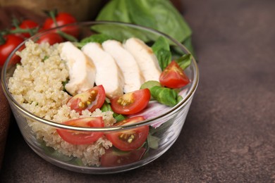 Photo of Delicious quinoa salad with chicken and cherry tomatoes served on grey textured table, closeup